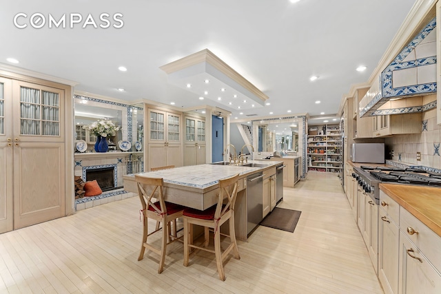 kitchen featuring gas stovetop, decorative backsplash, a large island, dishwasher, and a tiled fireplace