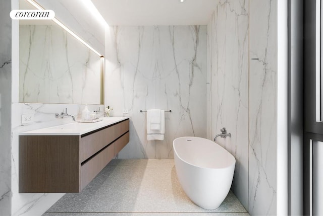 bathroom featuring vanity, a bathing tub, and tile walls