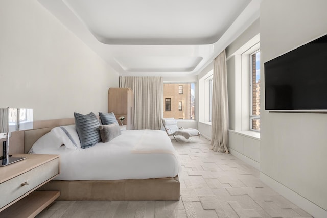 bedroom featuring a tray ceiling and light colored carpet