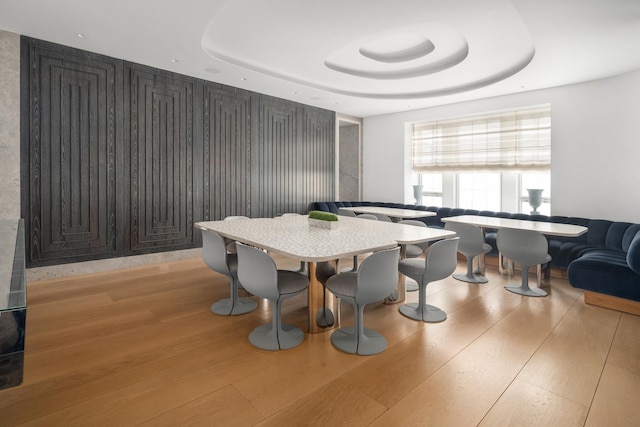 dining space featuring a tray ceiling and wood finished floors