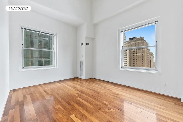 empty room featuring baseboards, visible vents, and light wood-style floors