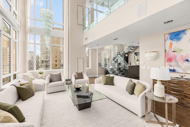 living room featuring hardwood / wood-style flooring, plenty of natural light, and a towering ceiling