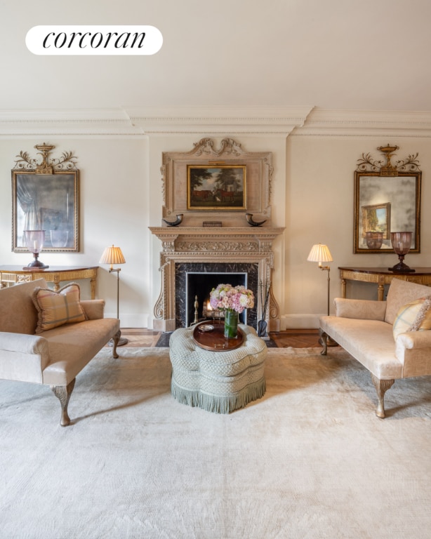 living room with a high end fireplace and crown molding