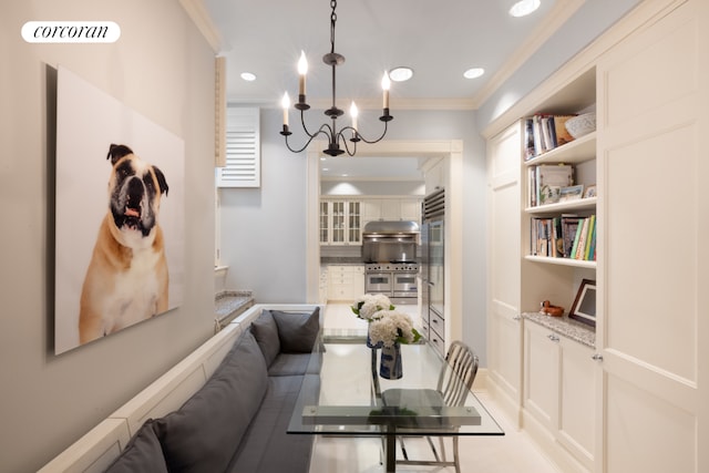 living room with built in features, ornamental molding, and a chandelier