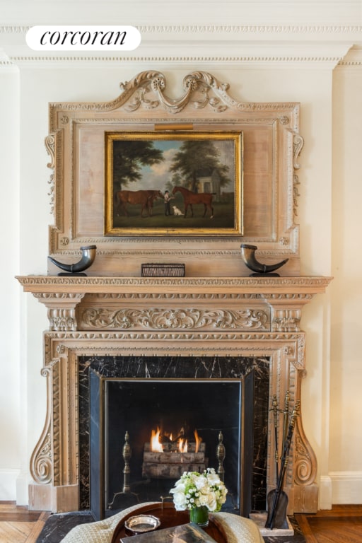 room details featuring hardwood / wood-style flooring, ornamental molding, and a premium fireplace