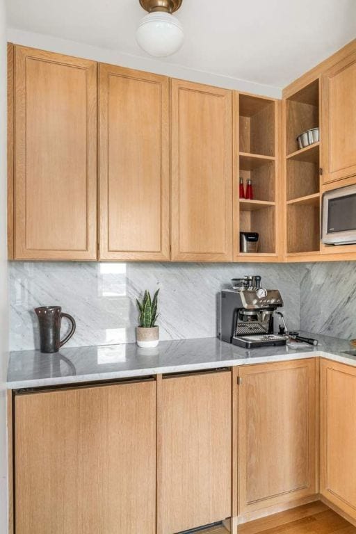 kitchen featuring light brown cabinets, wood-type flooring, and tasteful backsplash