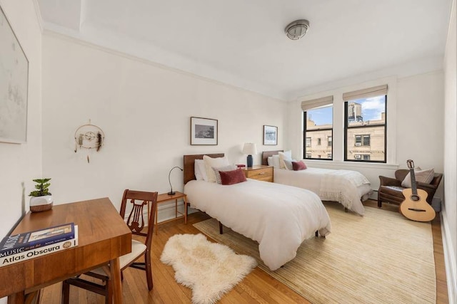 bedroom featuring crown molding and wood-type flooring