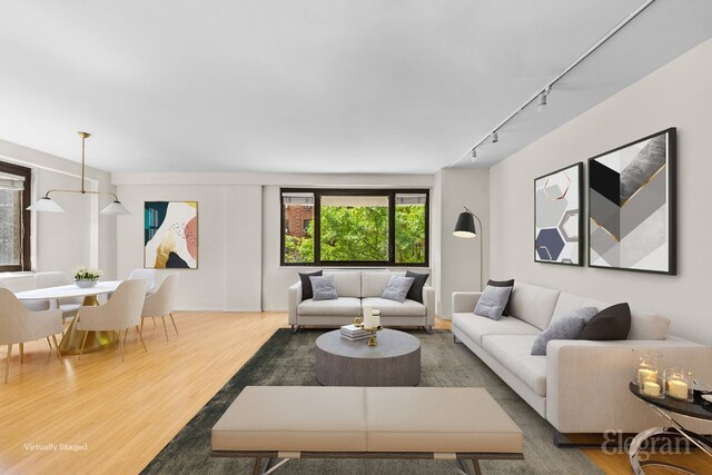 living room with wood-type flooring and track lighting