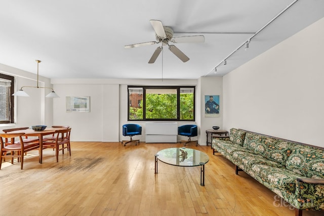 living room featuring ceiling fan, rail lighting, and light wood-type flooring