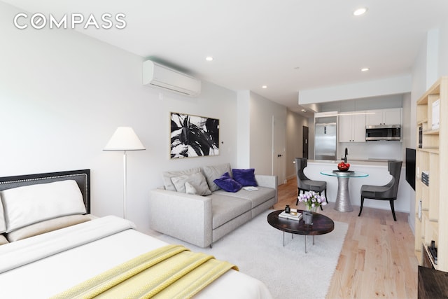 living room with light wood-style floors, recessed lighting, and an AC wall unit