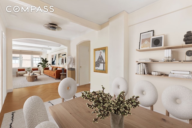 dining room with arched walkways, beam ceiling, crown molding, and baseboards