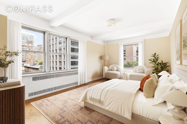 bedroom with beam ceiling, a city view, multiple windows, and radiator heating unit