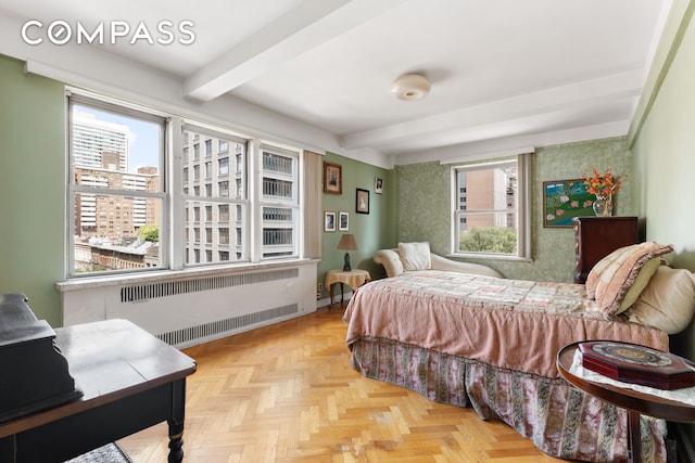 bedroom with radiator, multiple windows, baseboards, and beam ceiling