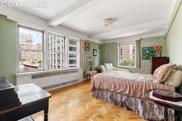 bedroom featuring radiator, light parquet floors, and beamed ceiling