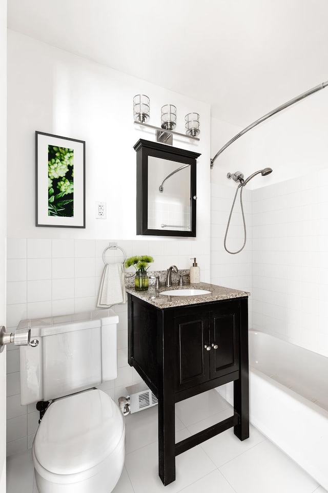 full bathroom with toilet, tiled shower / bath, tile walls, vanity, and tile patterned flooring