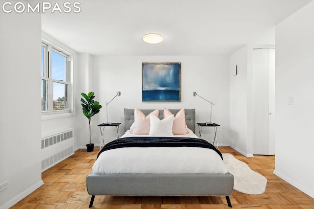 bedroom with radiator and light parquet flooring