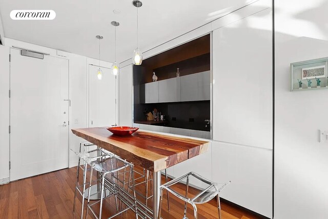 kitchen featuring pendant lighting, dark wood-type flooring, and a breakfast bar area