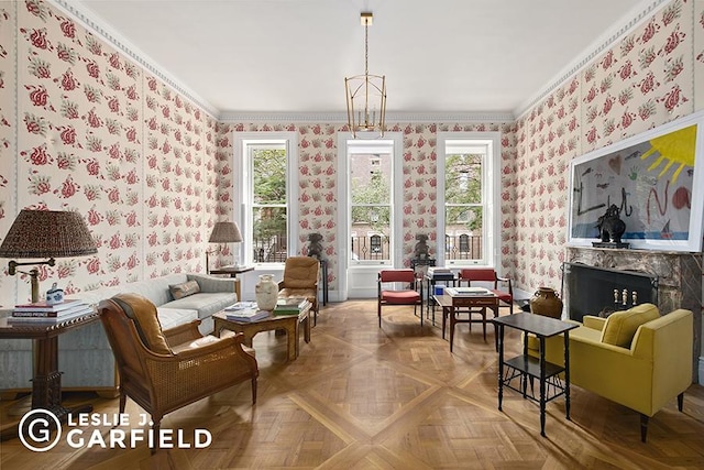 sitting room with crown molding, plenty of natural light, parquet floors, and a notable chandelier