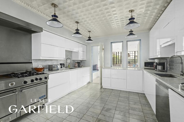 kitchen featuring white cabinetry, sink, stainless steel appliances, and hanging light fixtures