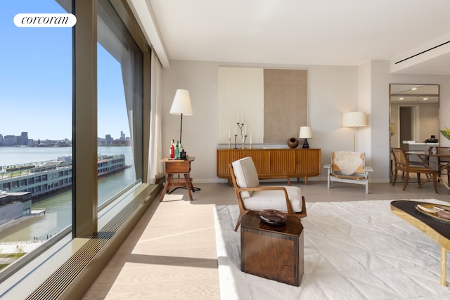 sitting room with a city view, baseboards, and a water view