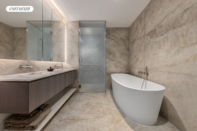 bathroom featuring double vanity, a stall shower, tile walls, visible vents, and a freestanding tub