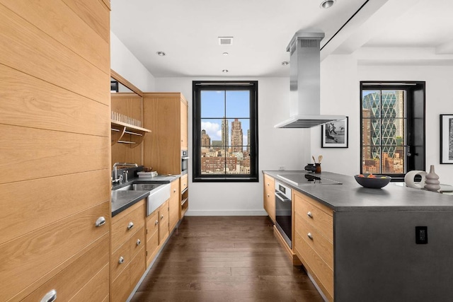 kitchen featuring black electric stovetop, oven, sink, island exhaust hood, and dark hardwood / wood-style flooring