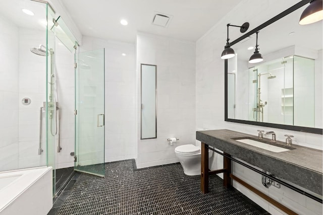 bathroom featuring toilet, tile walls, tile patterned floors, sink, and a shower with door