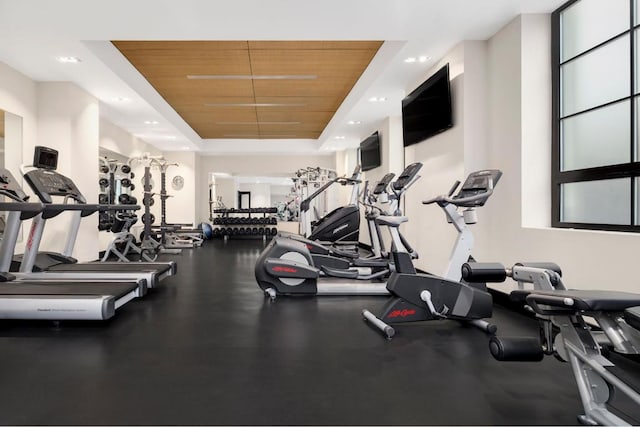 exercise room featuring a raised ceiling and wooden ceiling