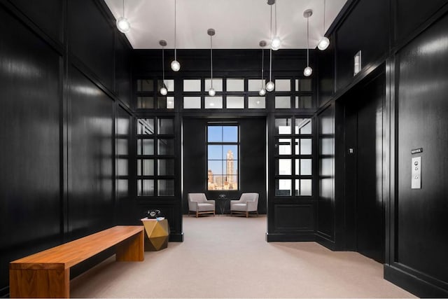 mudroom with carpet floors and a high ceiling