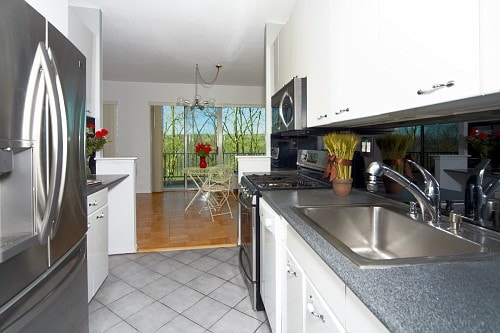 kitchen featuring sink, light tile patterned floors, white cabinets, and appliances with stainless steel finishes