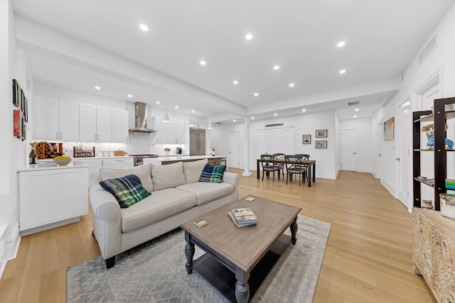 living room featuring light wood-style flooring, recessed lighting, and visible vents