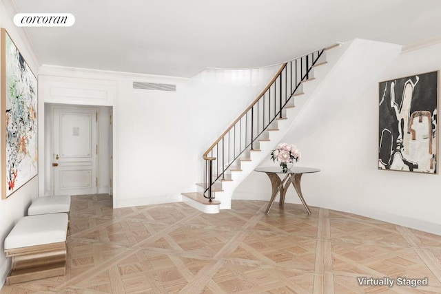 staircase with parquet floors and ornamental molding