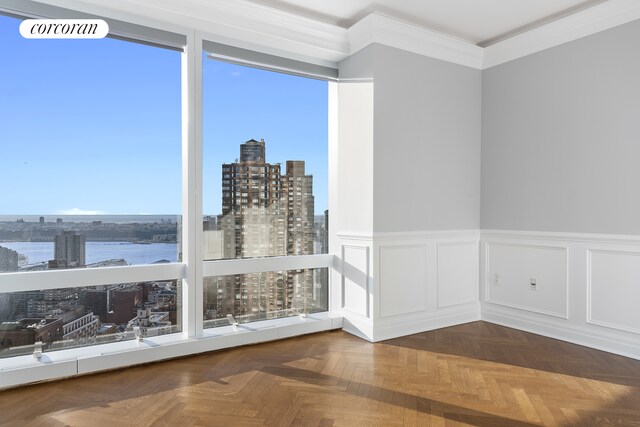 25 Columbus Cir Unit 55F, New York City, NY 10019 - unfurnished room featuring a city view, ornamental molding, a wainscoted wall, and a water view