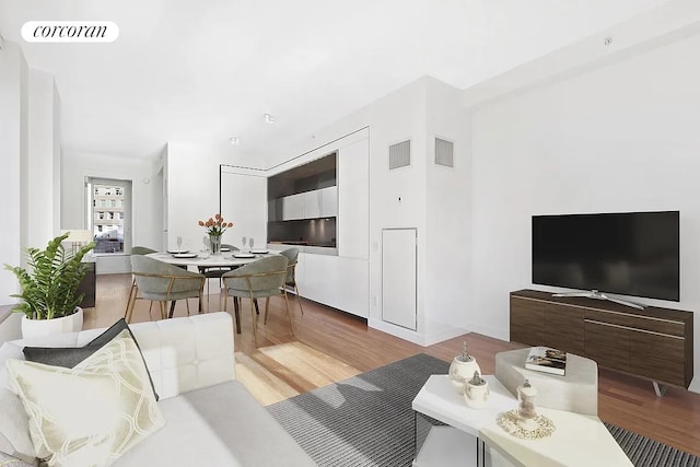 living room featuring visible vents and wood finished floors