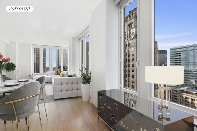 interior space featuring a view of city, visible vents, a healthy amount of sunlight, and wood finished floors