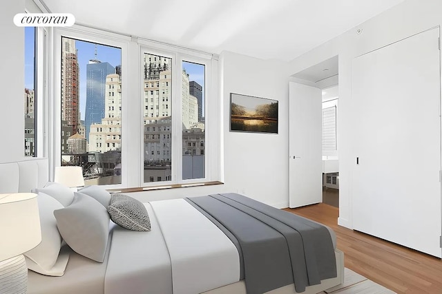 bedroom featuring wood finished floors and a city view