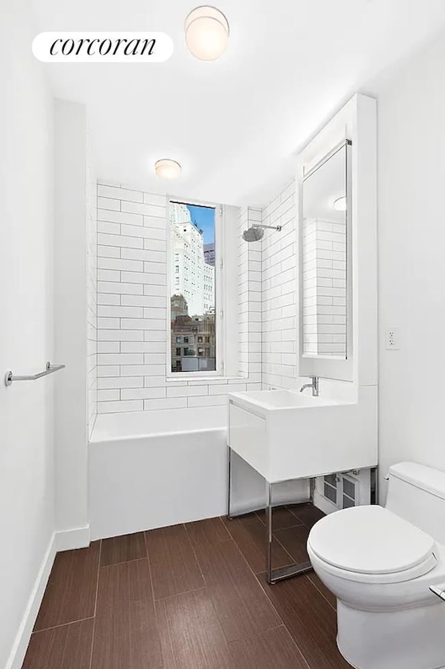 full bath featuring shower / bathtub combination, toilet, and wood finished floors
