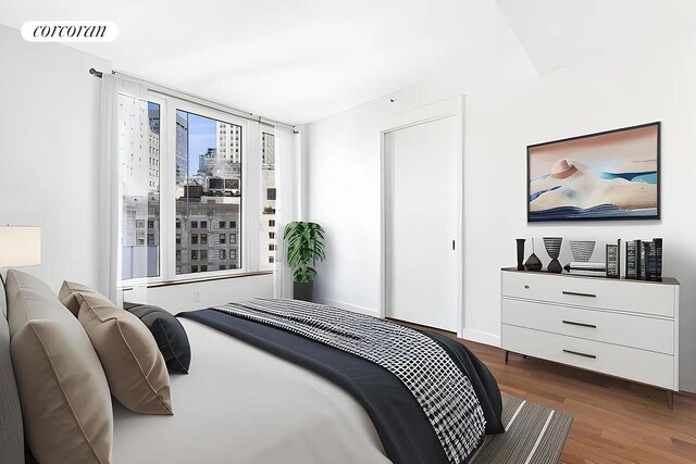 bedroom with a city view, wood finished floors, and visible vents