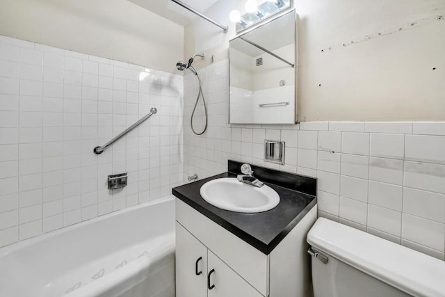 full bathroom with  shower combination, toilet, tile walls, and vanity