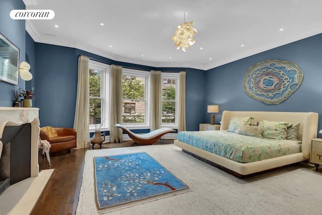 bedroom featuring a fireplace with raised hearth, ornamental molding, recessed lighting, wood finished floors, and a notable chandelier