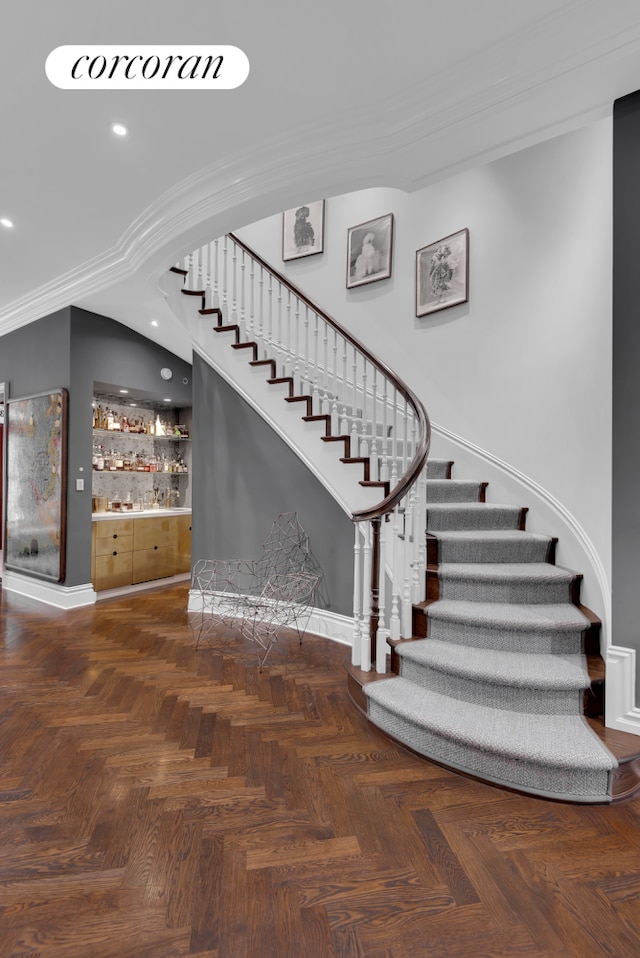 stairs featuring recessed lighting, baseboards, a bar, and ornamental molding