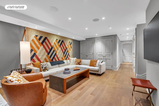 living room featuring visible vents, baseboards, light wood-style flooring, recessed lighting, and an accent wall