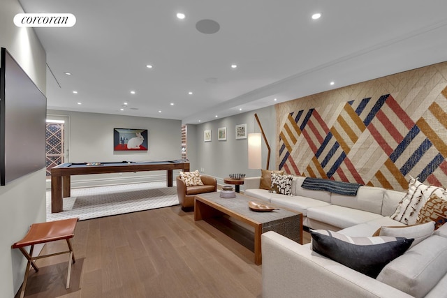 living area with recessed lighting, visible vents, wood finished floors, and an accent wall