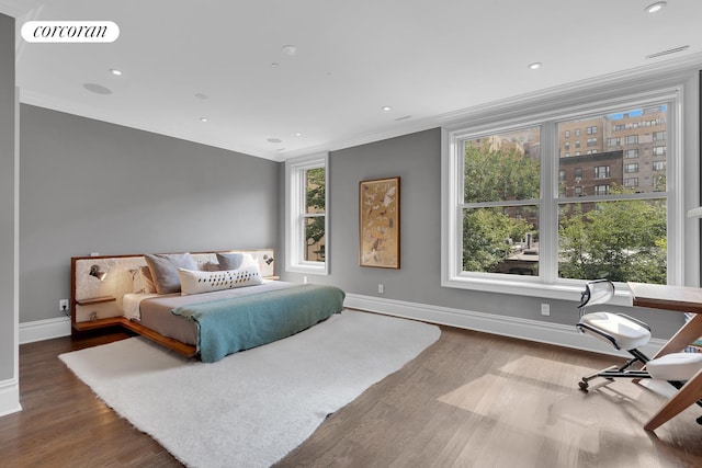 bedroom featuring crown molding, multiple windows, wood finished floors, and visible vents