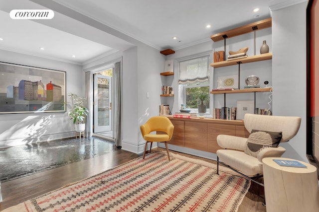 living area with visible vents, a healthy amount of sunlight, ornamental molding, and wood finished floors