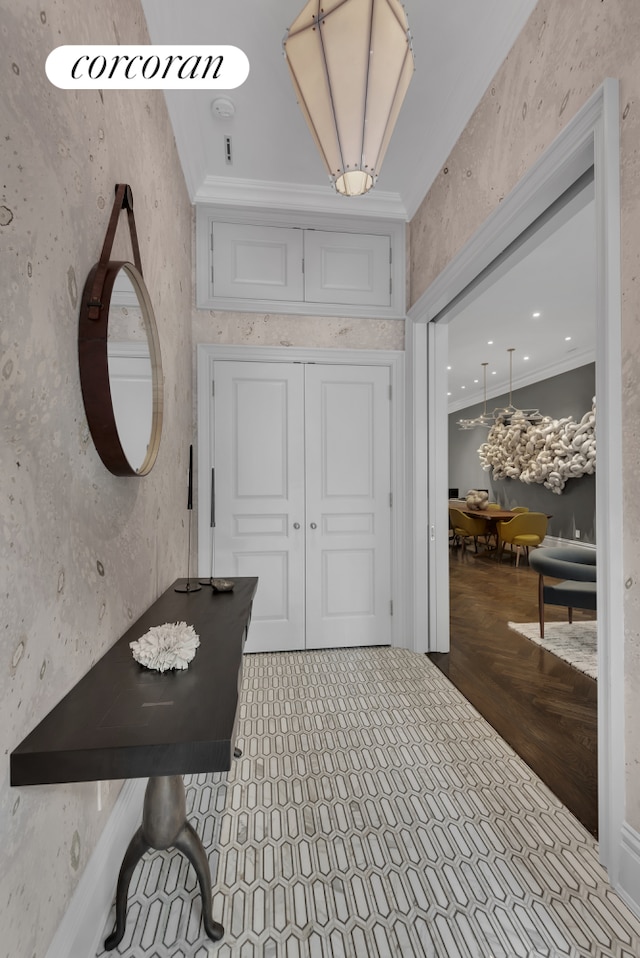 interior space featuring ornamental molding and wallpapered walls