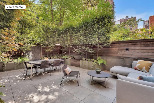 view of patio with an outdoor living space, a fenced backyard, and outdoor dining space