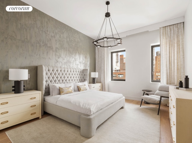 bedroom with light hardwood / wood-style floors and a chandelier