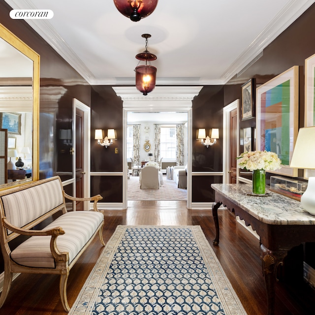 hall featuring crown molding, baseboards, wood finished floors, and visible vents