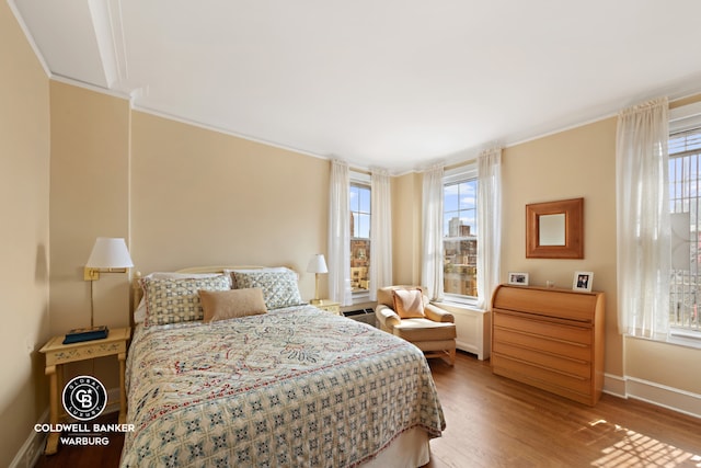 bedroom featuring ornamental molding and wood-type flooring